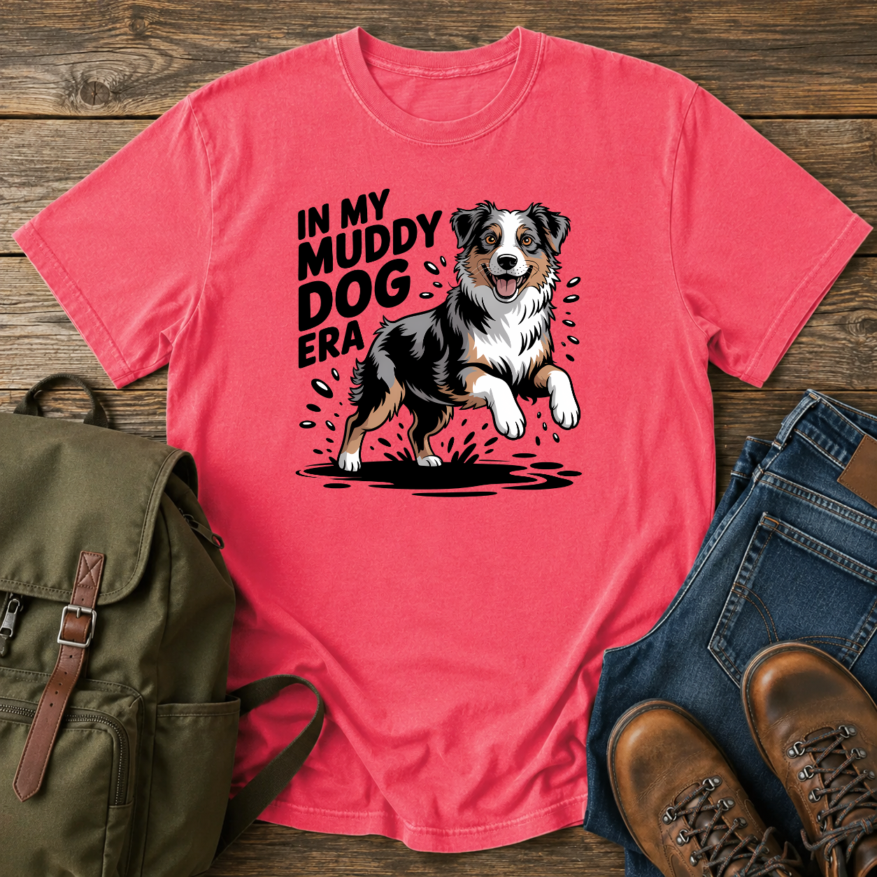 Australian Shepherd dog shaking off muddy creek water on a retro outdoor t-shirt design.