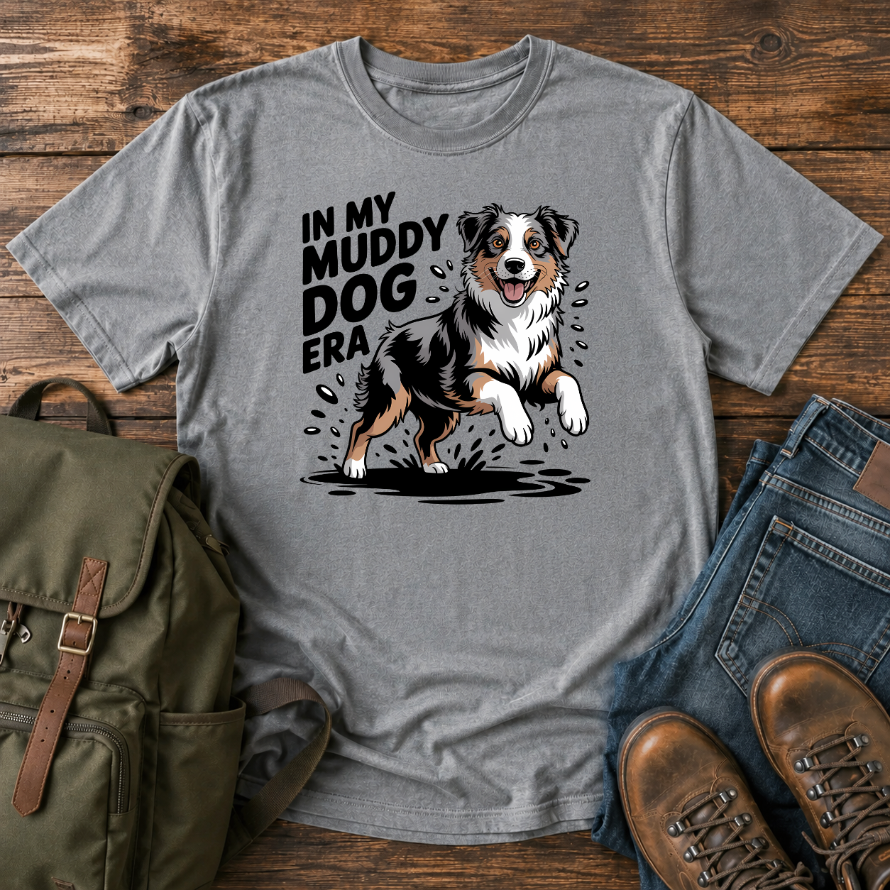 Australian Shepherd dog shaking off muddy creek water on a retro outdoor t-shirt design.