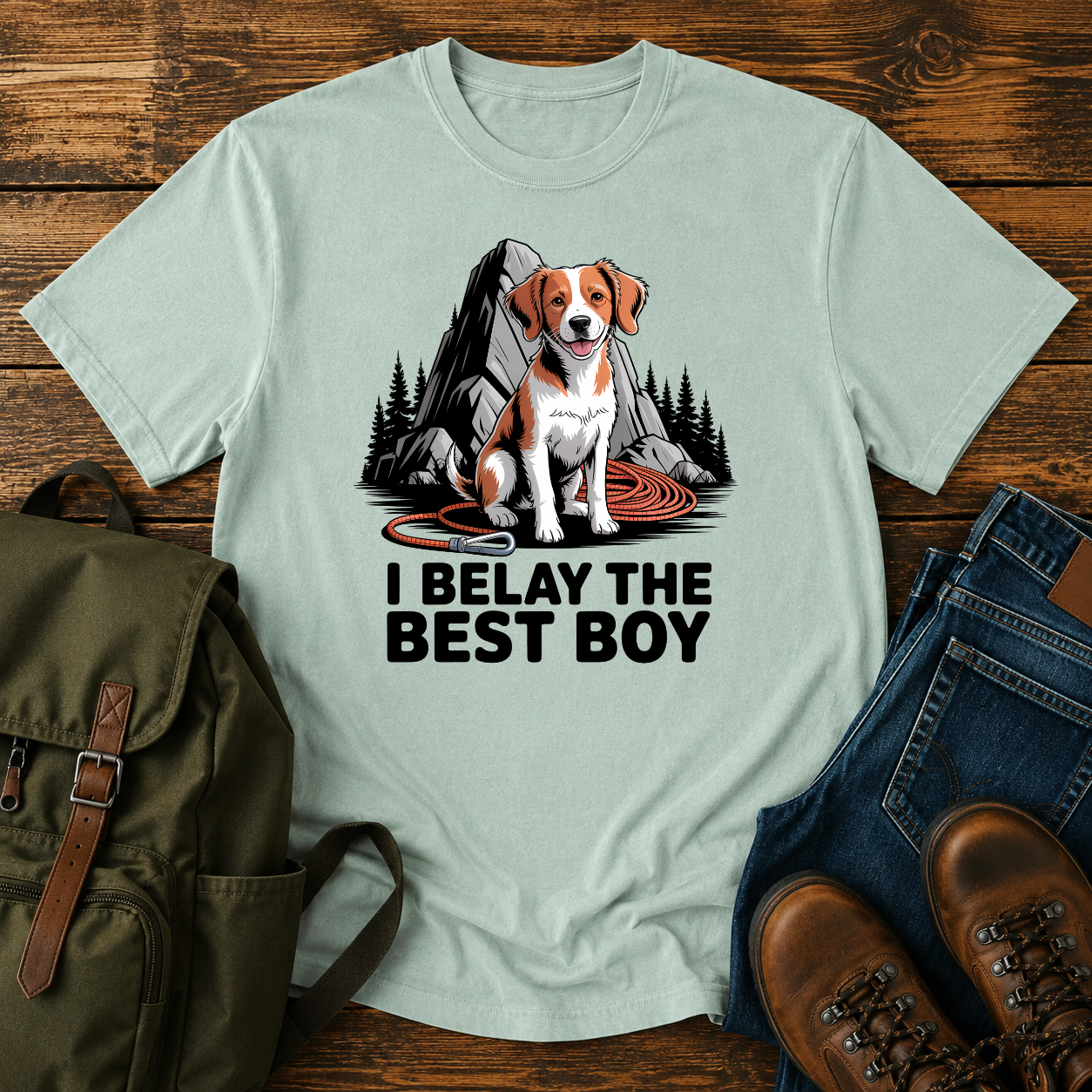 Brittany spaniel at granite boulder base with coiled climbing rope and carabiner on t-shirt