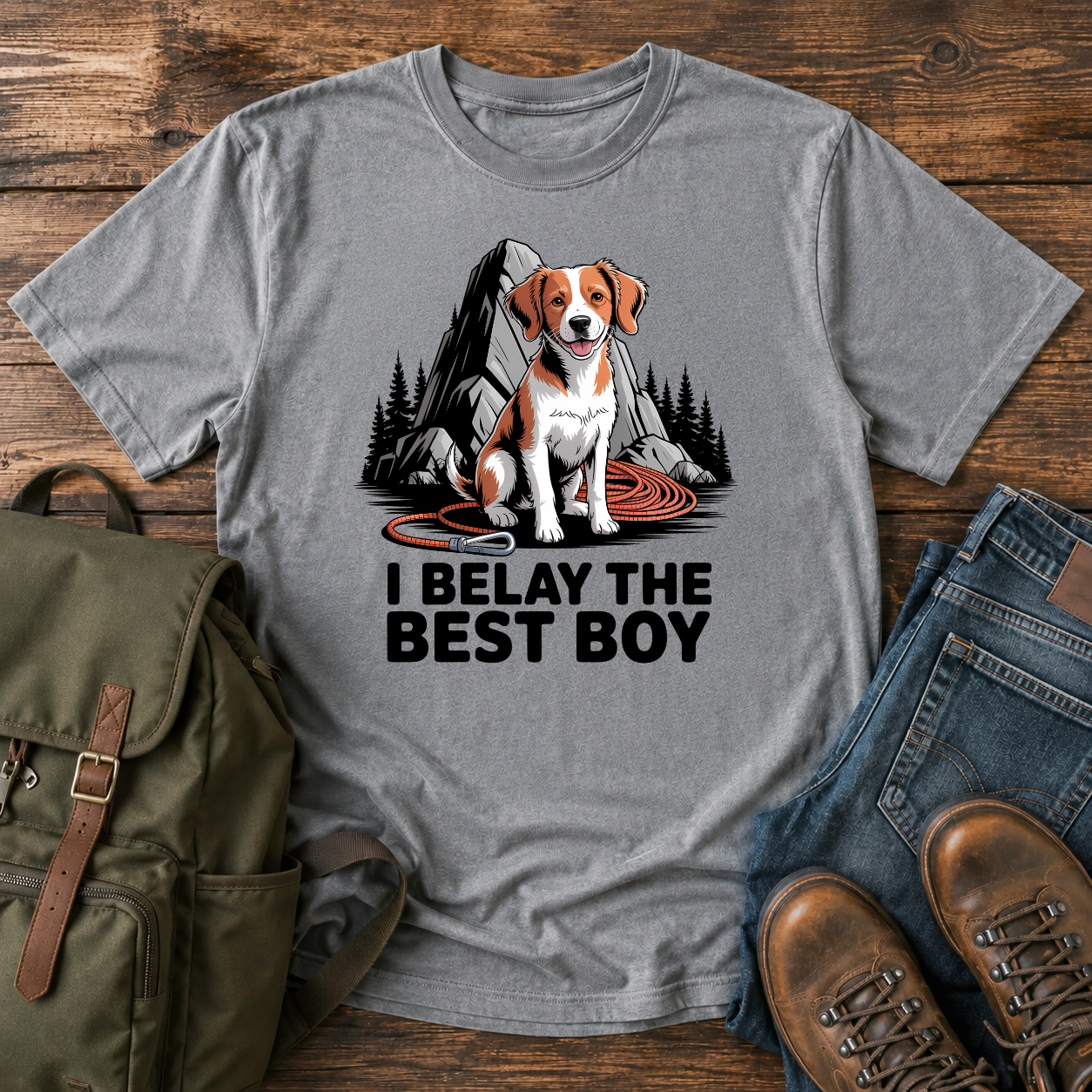 Brittany spaniel at granite boulder base with coiled climbing rope and carabiner on t-shirt