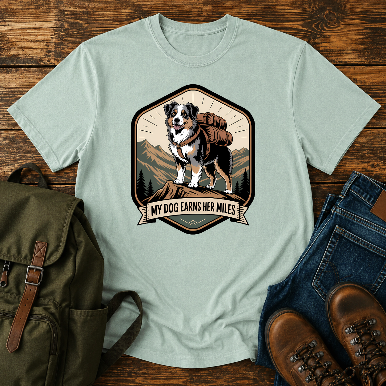 Retro trail-badge Australian Shepherd hiking shirt featuring an Aussie with a backpack on a mountain thru-hike trail.
