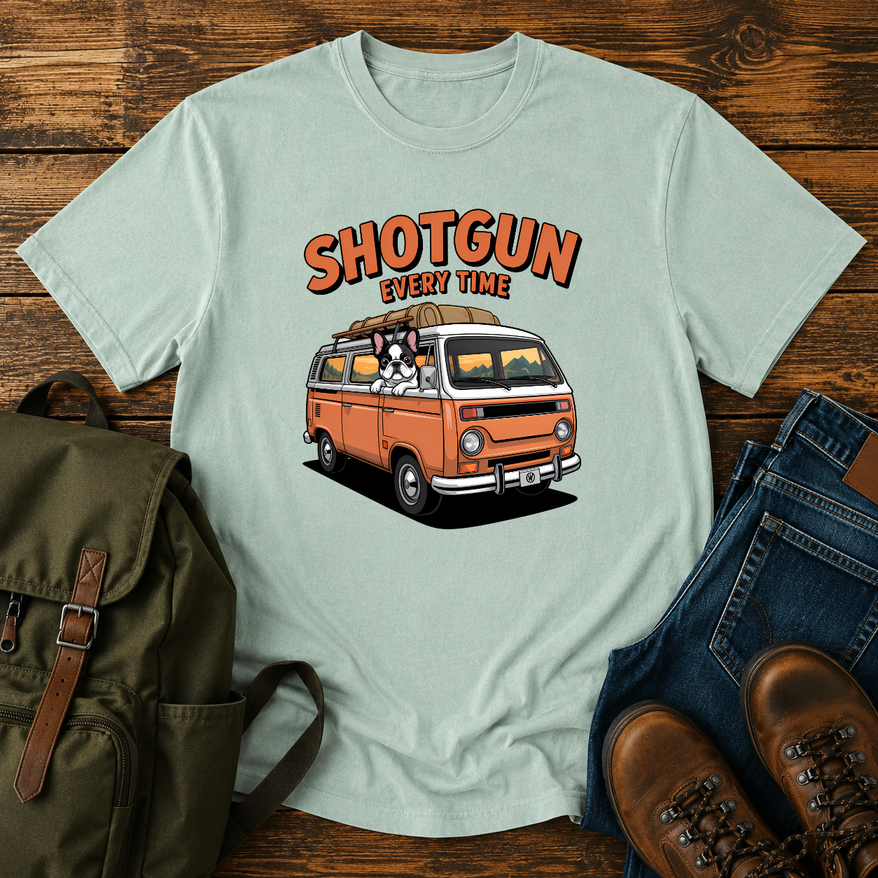 French Bulldog sitting shotgun in a retro camper van with mountain scenery on a vintage-style t-shirt.
